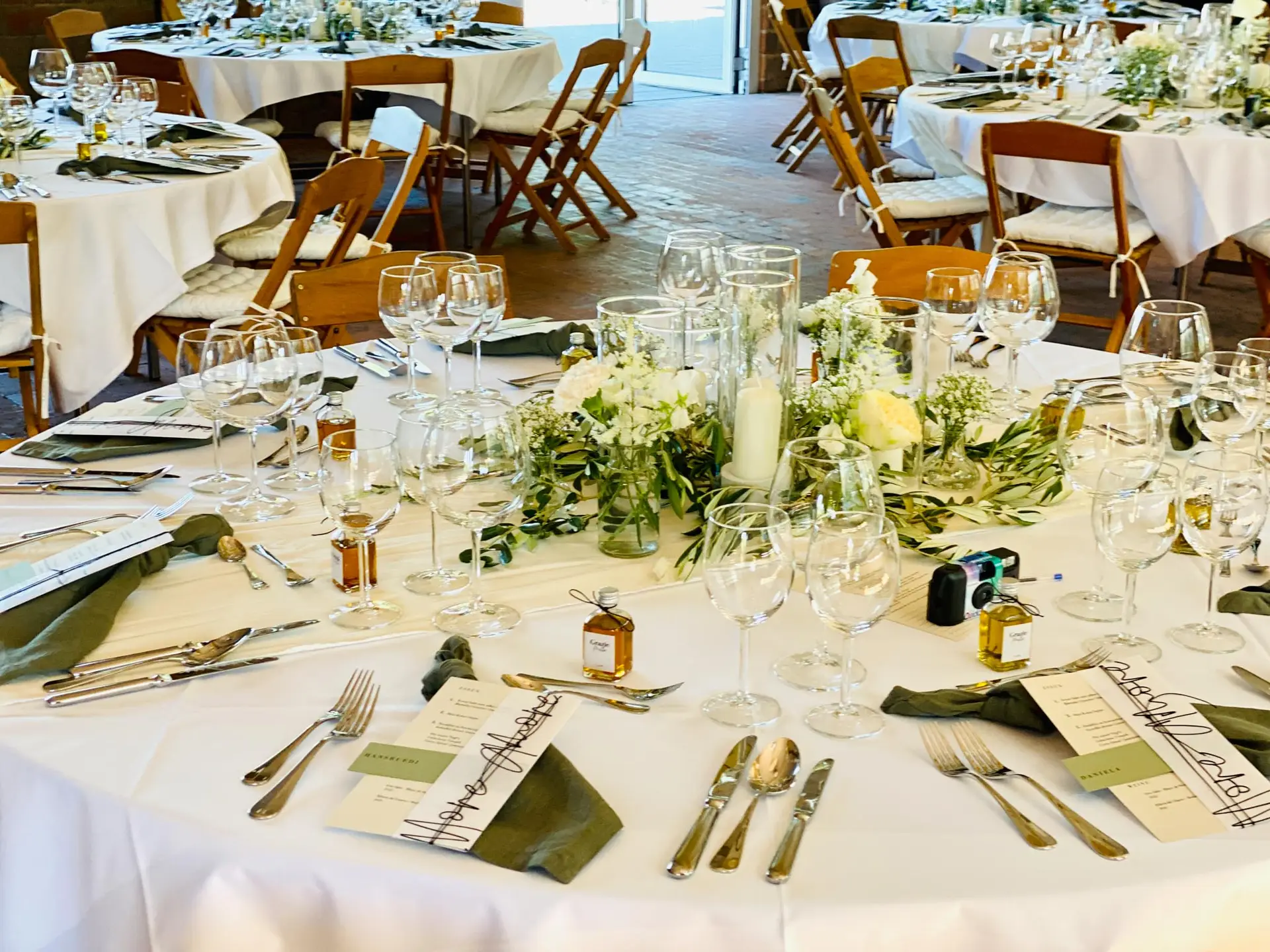 Festlich gedeckte Hochzeitstafel mit Grün und Kerzen